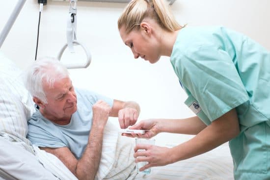 Senior avec infirmière dans la maison de soins infirmiers.